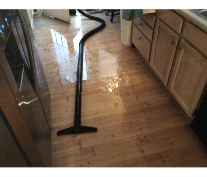 vacuum wand and black hose on floor of kitchen